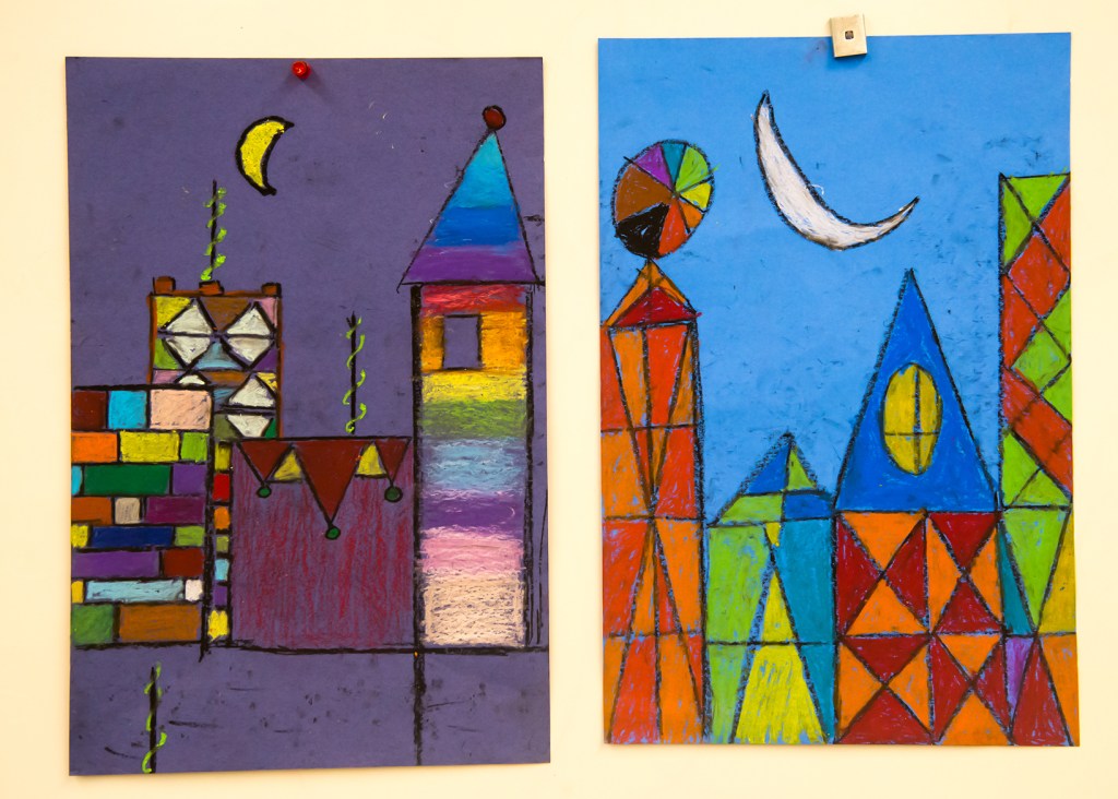 Two 3rd grade students' oil pastel "cityscapes" inspired by Paul Klee's magic square paintings