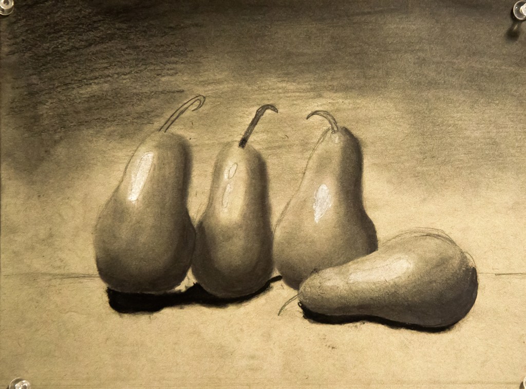 6th grade - chiaroscuro still life drawing in graphite and charcoal representing four pears on a table, one being tipped over