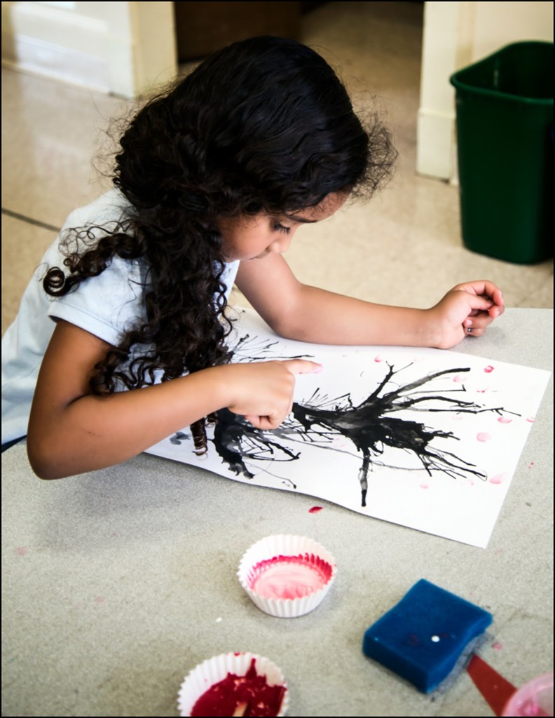 1st grade student applying the blossoms with her fingers