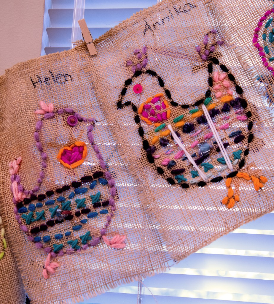 Two examples of 3rd grade students' sewing samplers depicting colorful, whimsical chickens