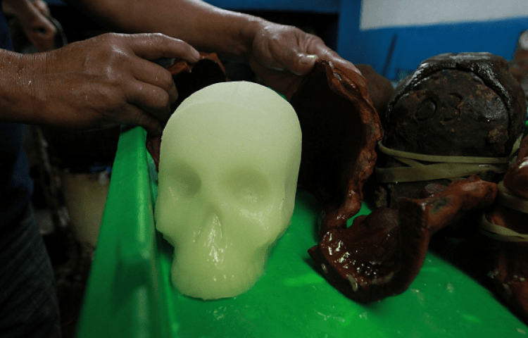 A sugar skull being freed from the mold