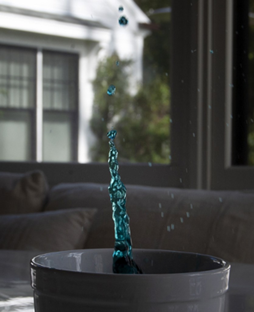 An 8th grade student using shutter speed to capture still motion of a drop of water