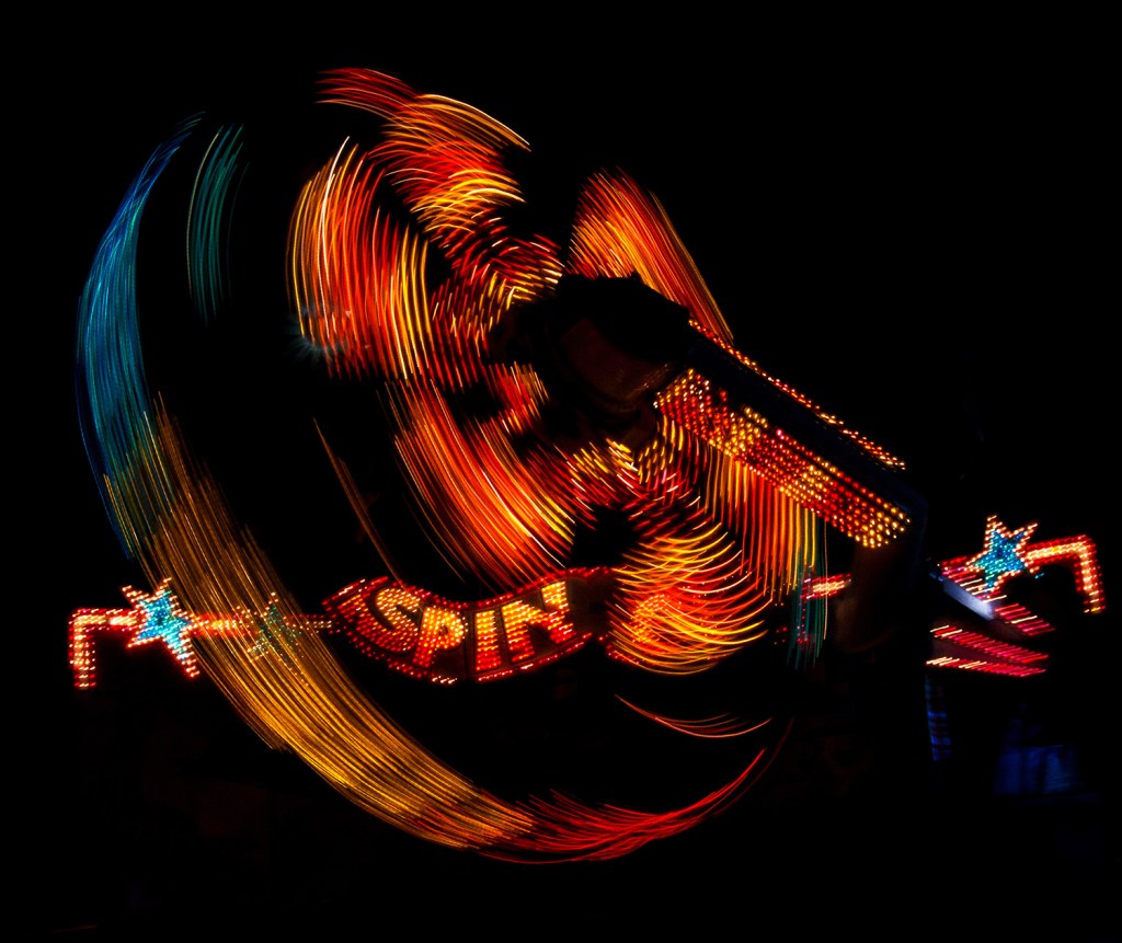 A slower shutter speed captures the motion of this lit amusement park ride ay night. "Lights of Alameda County Fair" © Anita Sagastegui