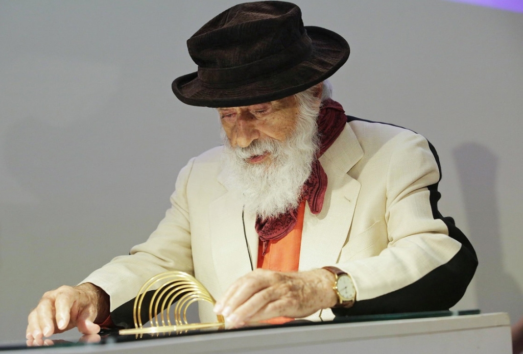 The artist Yaacov Agam demonstrating the fluid changeability of one of his kinetic art pieces. 