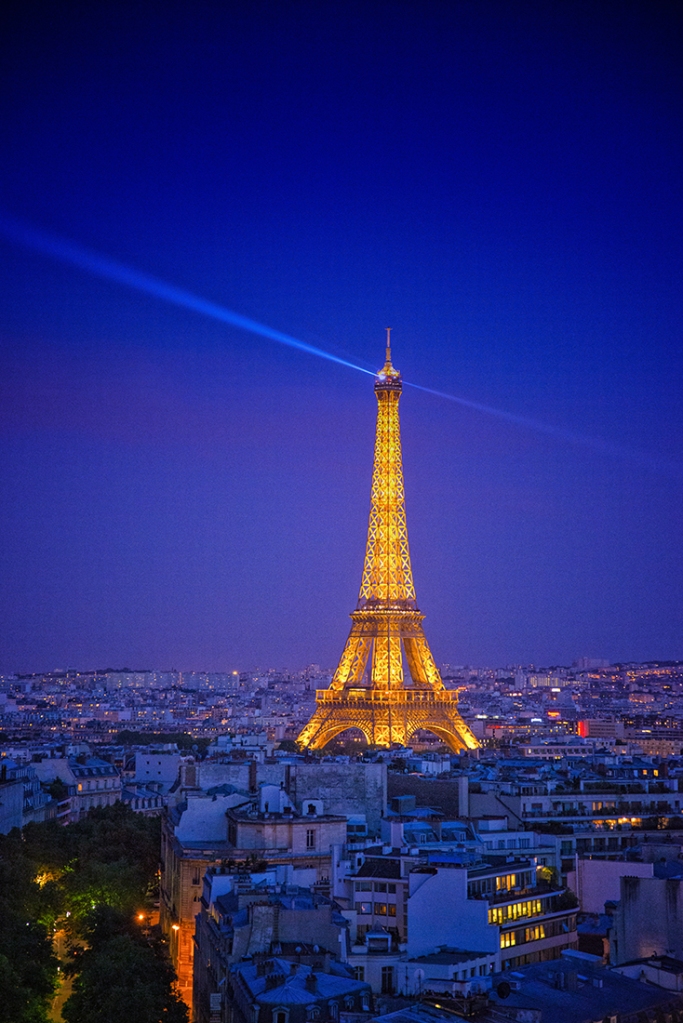 The Eiffel Tower lit up at night, in Paris, France, by Anita Sagastegui