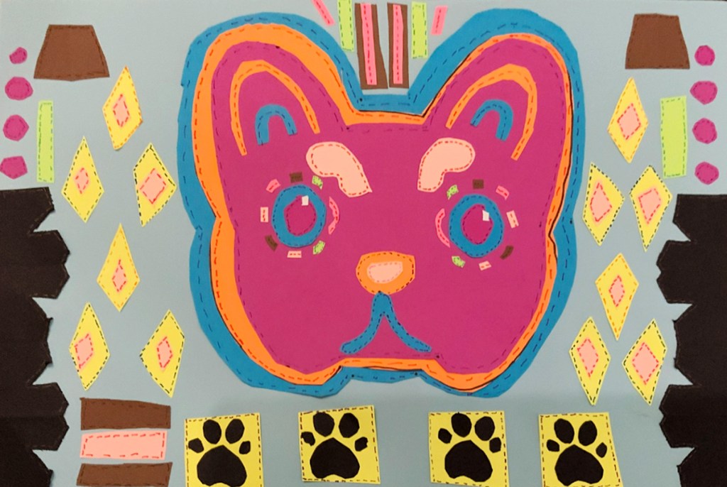 A 4th grade student Mola, depicting a variously colored cat's head and many layers of patterns, all adorned with "stitches" to look like a real Mola