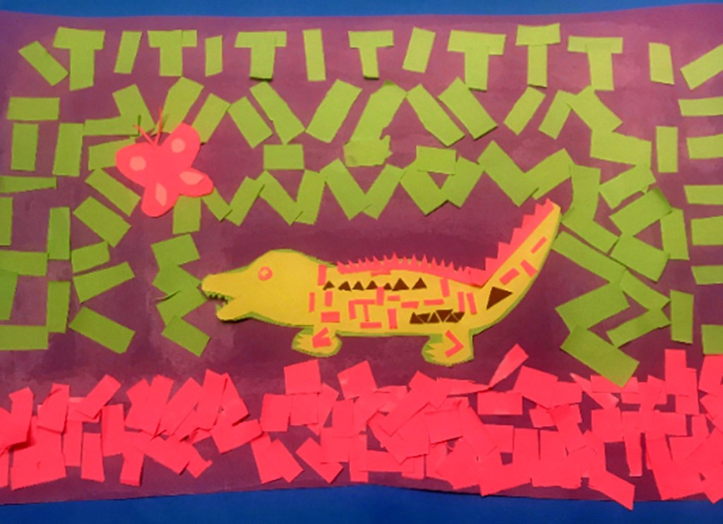 A 4th grade student Mola, depicting an intricately patterned yellow alligator surrounded by multicolored patterns in green and pink, with a pink butterfly