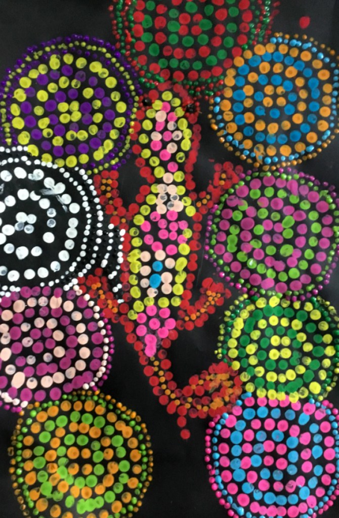 5th grade student's Aboriginal-style Dot Painting of a gecko set against circular patterns in vivid colors.