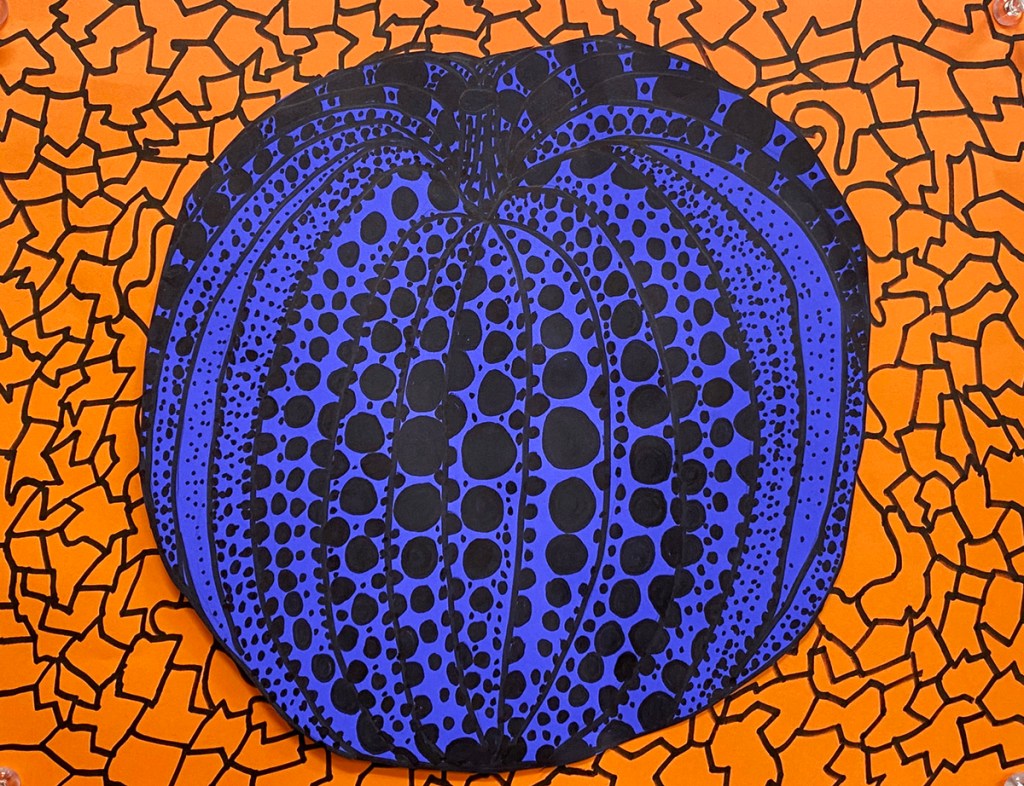 An example of a 5th grade student's Yayoi Kusama style polka-dot pumpkin on a vibrant, patterned background.