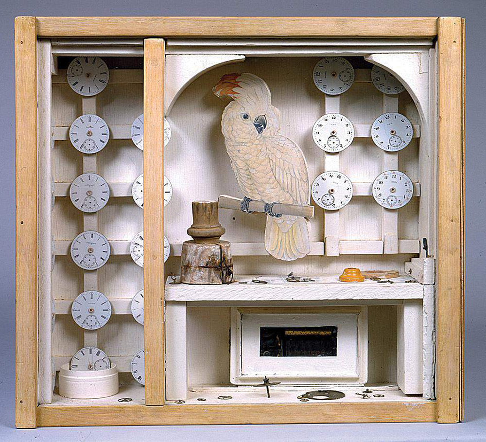 One of Joseph Cornell's memory boxes, titled Cockatoo with Watch faces. Features several different watch faces, watch parts, and a paper cockatoo.