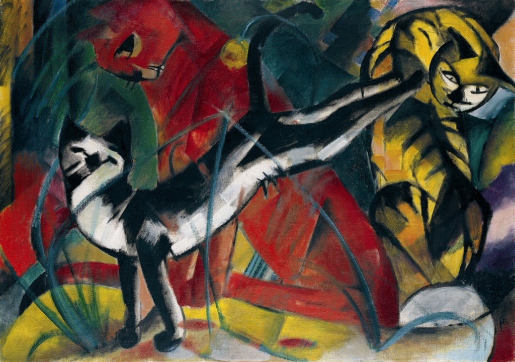 Three Cats, Franz Marc, 1913. A painting of dancing cats, one yellow, one red and one black & white.