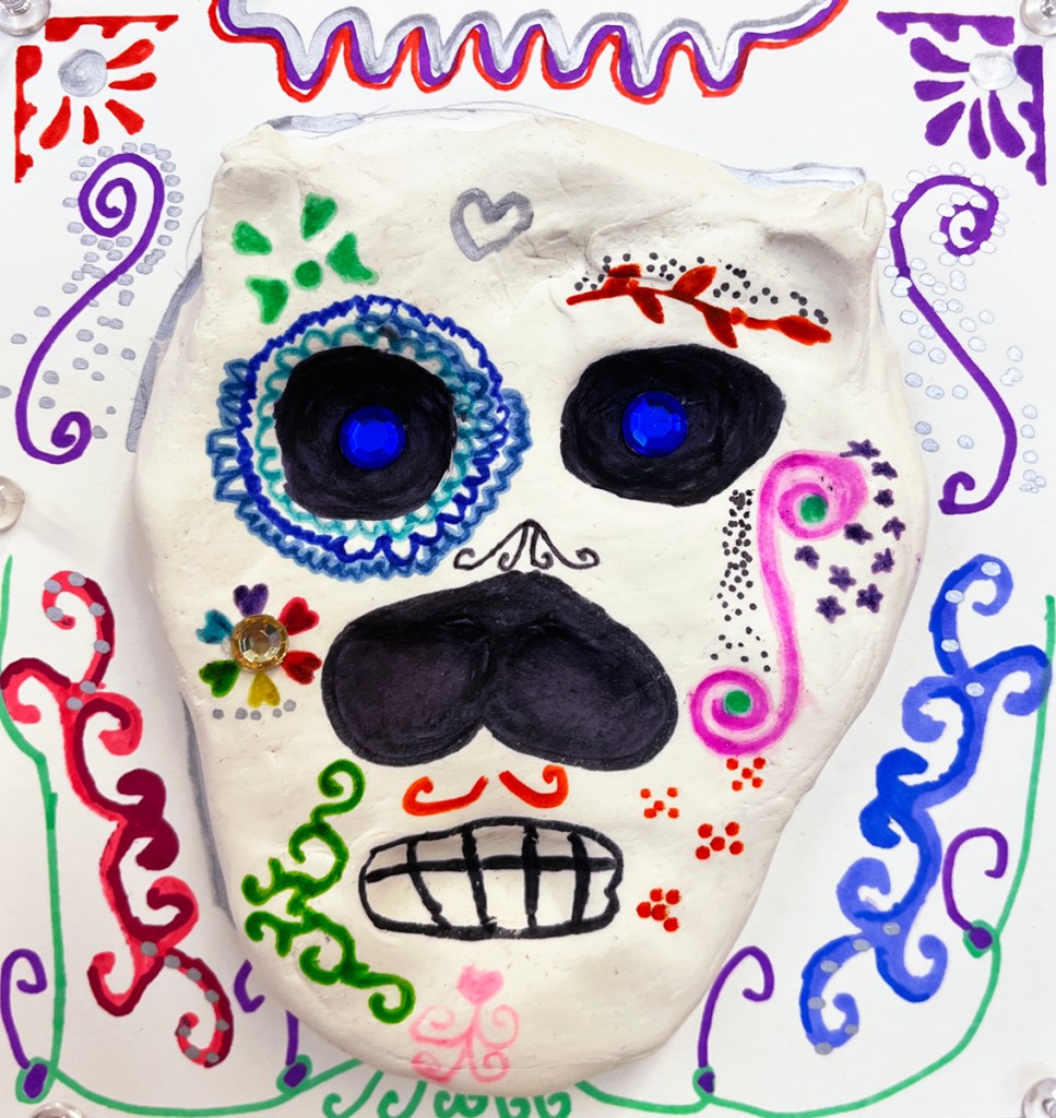 4th grade calaveras- Dia de los Muertos "sugar" skulls made out of model magic clay and decorated in multicolors of markers and sharpies, as well as plastic "gems", and placed on a decorative background in various designs and patterns, also made by the students