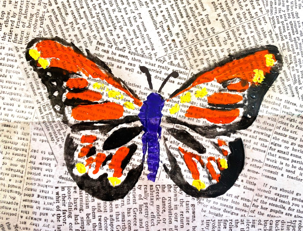 An 8th grade student's linoleum block print. This student used a scrapbook-style newsprint paper to print her orange, yellow and purple butterfly.