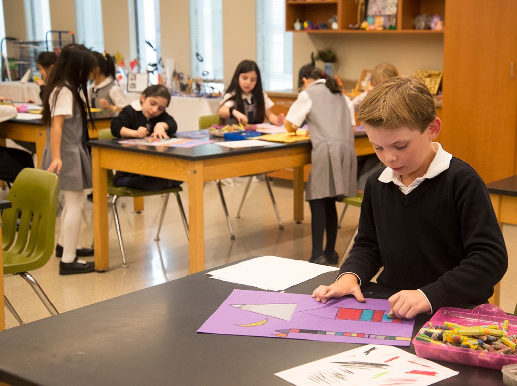 Several 3rd grade students in the art studio, working on their magic square cities