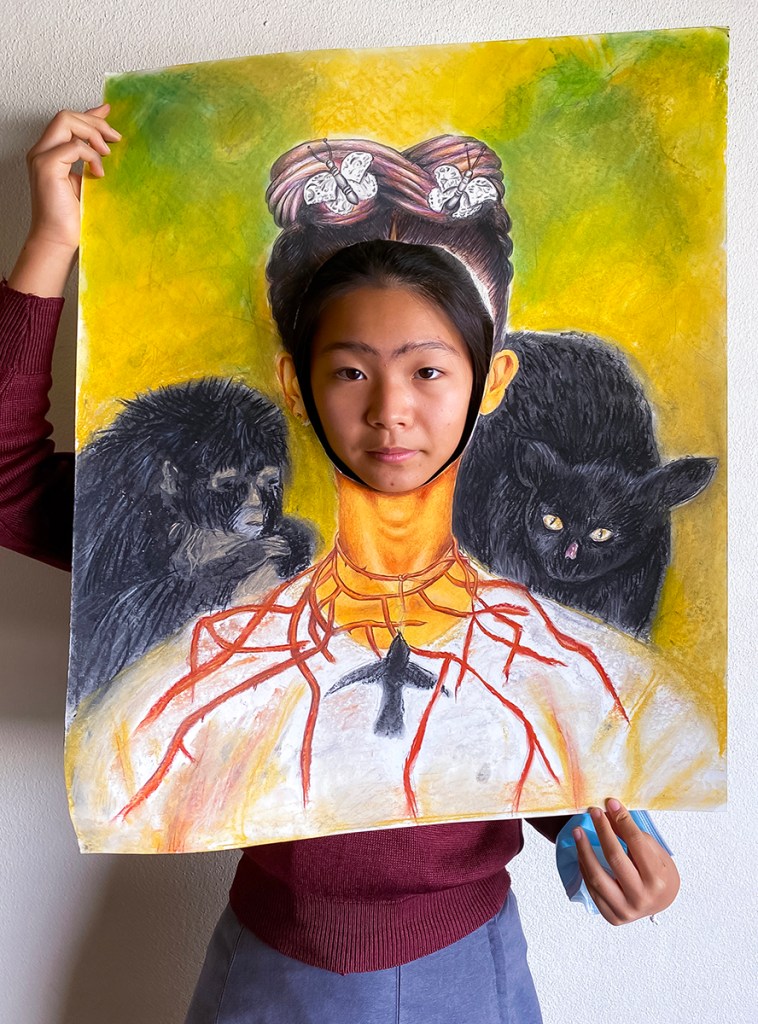 A student "dressed up" in her recreation of one of Frida Kahlo's self-portraits with two monkeys.