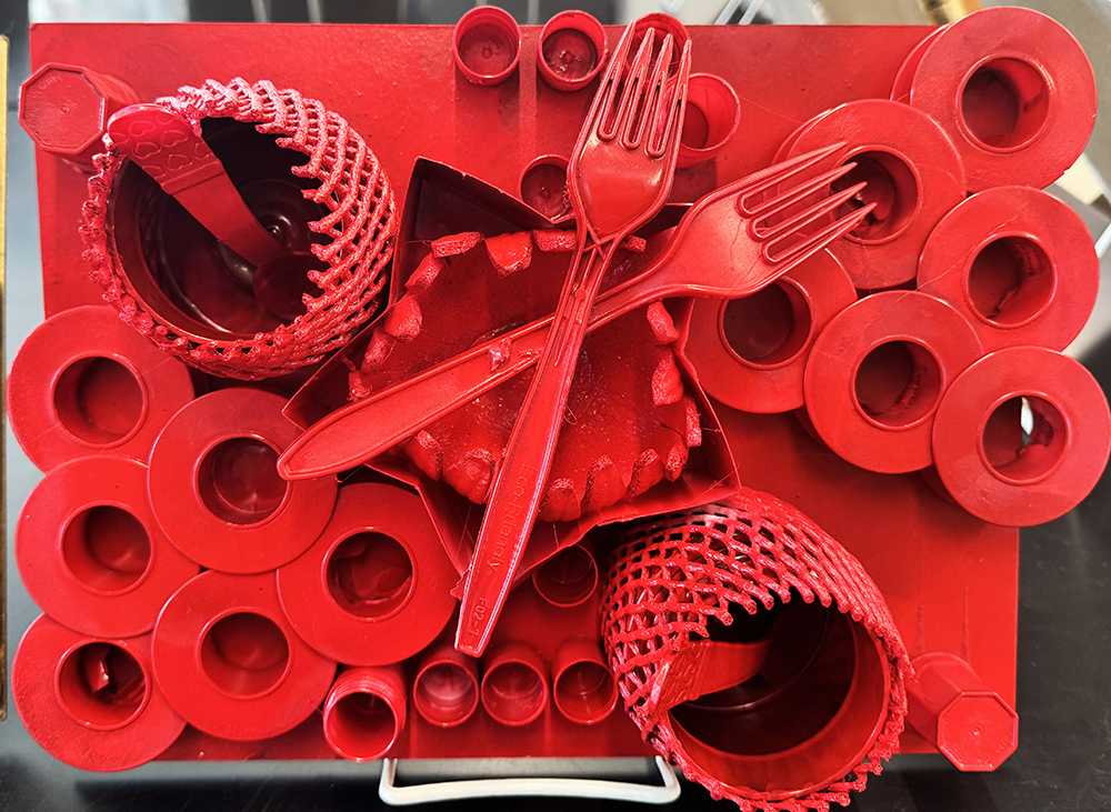 An example of a Louise Nevelson-inspired, found art assemblage, painted completely in red, created by a pair of 5th grade students working together